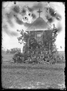 A group of military men in front of a wooden chapel