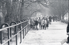 Ogród Saski w Lublinie zimą - wycieczka szkolna idąca po chodniku wzdłuż ogrodzenia