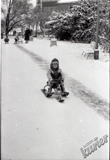 Ogr&oacute;d Saski w Lublinie zimą - ślizagawka przy gł&oacute;wnym wejściu i chłopiec na nartosankach