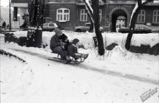 Ogr&oacute;d Saski w Lublinie zimą - zjazd tr&oacute;jki dzieci na sankach przy samym gł&oacute;wnym wejściu