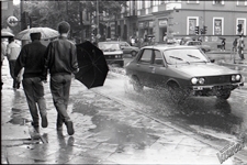 Krakowskie Przedmieście w Lublinie podczas deszczu - zasłanianie się parasolem przed ochlapaniem