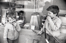 Dzieci z zabawkami posilające się przy witrynie sklepu w Lublinie