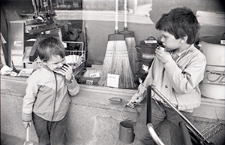 Dzieci z zabawkami posilające się przy witrynie sklepu w Lublinie