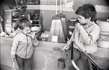 Dzieci z zabawkami posilające się przy witrynie sklepu w Lublinie