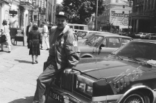 Osoba stojąca przy samochodzie na Krakowskim Przedmieściu w Lublinie