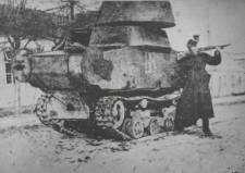 Żołnierz pozujący przy zdobycznym czołgu na ulicy w Kupiczowie