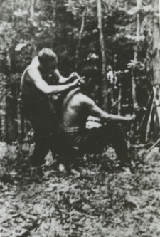 Żołnierz podcinający włosy kompanowi z batalionu