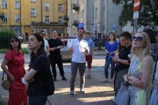 Mariusz Tarkawian oprowadza grupę podczas spaceru miejskiego "Dwa murale"