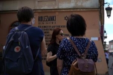 Uczestnicy spaceru miejskiego "Topografia Pamięci" na ulicy Kowalskiej przy muralu "Koleżanki"