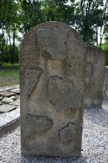 Fragmenty macew na betonowej steli na cmentarzu żydowskim w Chełmie