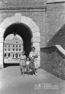Kobieta z dzieckiem przy bramie pod ulicą Zamkową w Lublinie