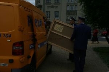 Pracownicy Poczty Polskiej transportujący zapakowaną urnę wyborczą