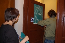 Adam Marczuk wiesza plakat Festiwalu