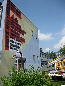 Grafficiarze w trakcie wykonywania murala z wierszem Piotra Matywieckiego na ścianie VII LO