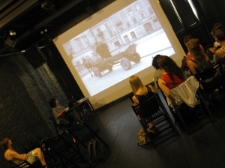 Uczestnicy warsztatu fotograficznego oglądający na rzutniku zdjęcia Stefana Kiełszni