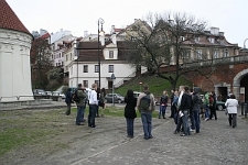 Ulica Podwale. Uczestnicy "Spaceru śladami Henia" przy Lampie Pamięci
