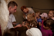 Michał Archanioł wręcza dzieciom płyty podczas premiery animacji "Miasto Podziemne"