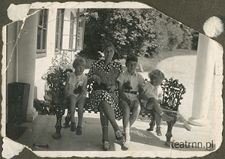 Hanna Dąbrowska z synem Krzysztofem oraz dziećmi z rodziny Olszowskich: Stefanem i Andrzejem na ławce przy wejściu dworu w Moniakach