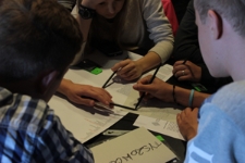 Grupa uczni&oacute;w z Tyszowiec podczas pracy nad mapą pamięci miejscowości, warsztat o dziedzictwie kulturowym miasteczka