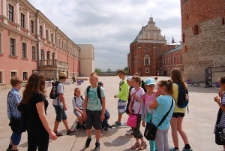 Uczestnicy spaceru z przewodnikiem Lubelskiej Trasy Podziemnej na dziedzińcu zamkowym.